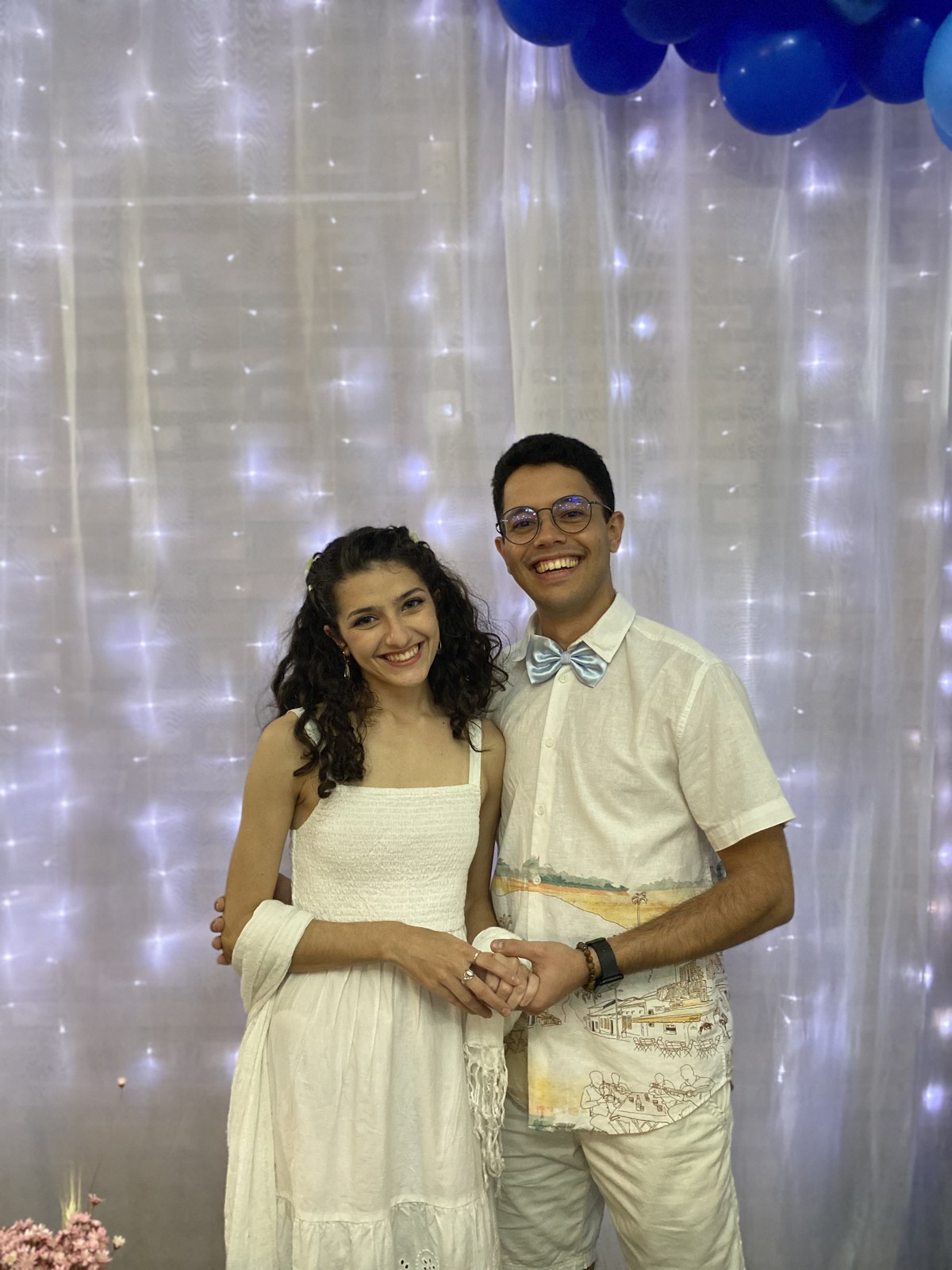 Mariana e Vinícius vestidos de branco no chá de panela, em julho de 2024