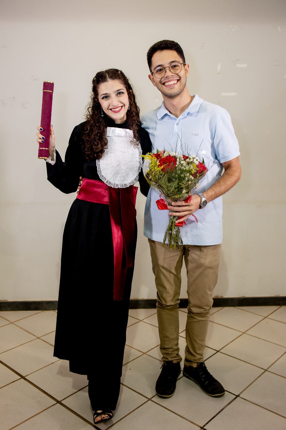 Mariana de beca no dia da sua formatura, ao lado de Vinícius, em outubro de 2024